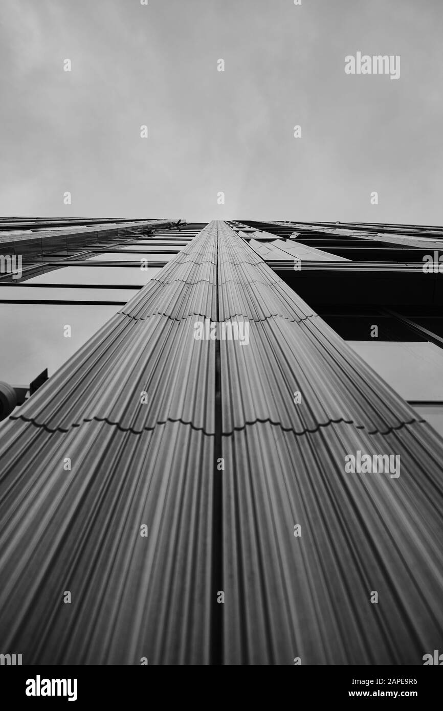 Low angle greyscale of a modern skyscraper under the cloudy sky Stock ...