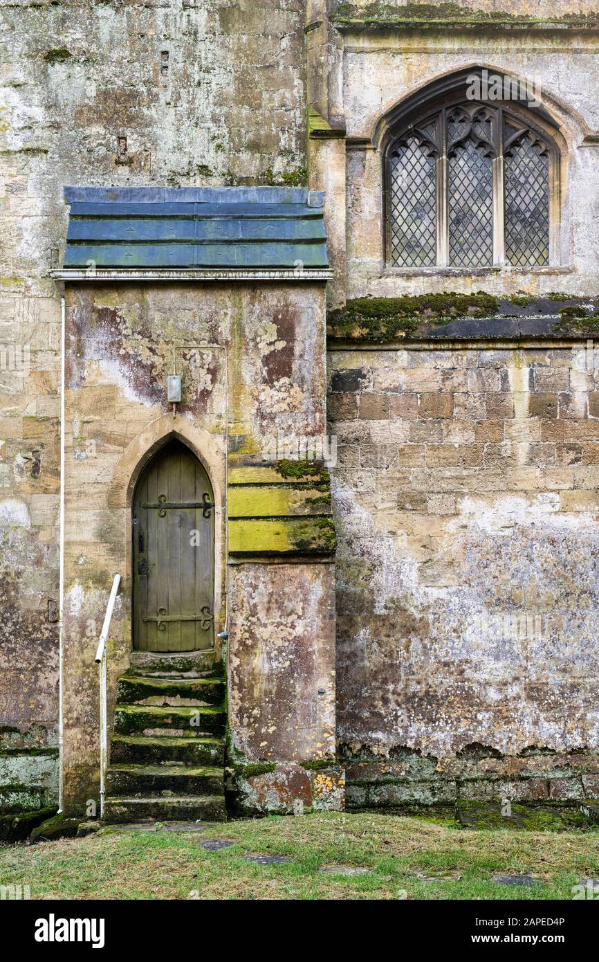 Old wooden door and steps in St Michael and All Angels Church. Withington, Gloucestershire, England Stock Photo