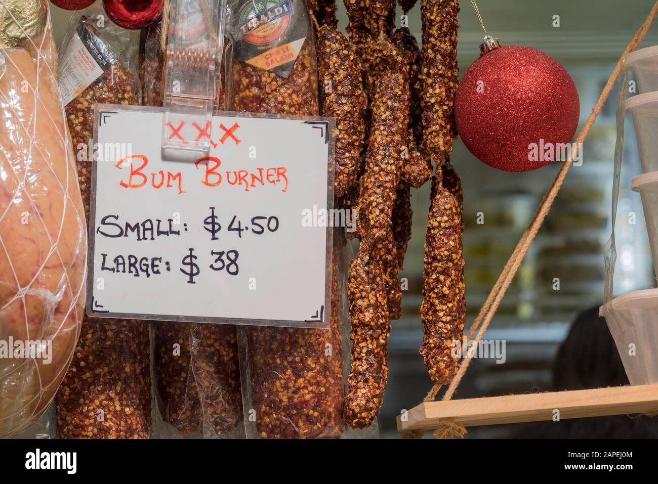Hot and spicy dried Salami labeled as Bum Burner (with added chili) hanging in a Queen Victoria Markets store in Melbourne, Australia Stock Photo