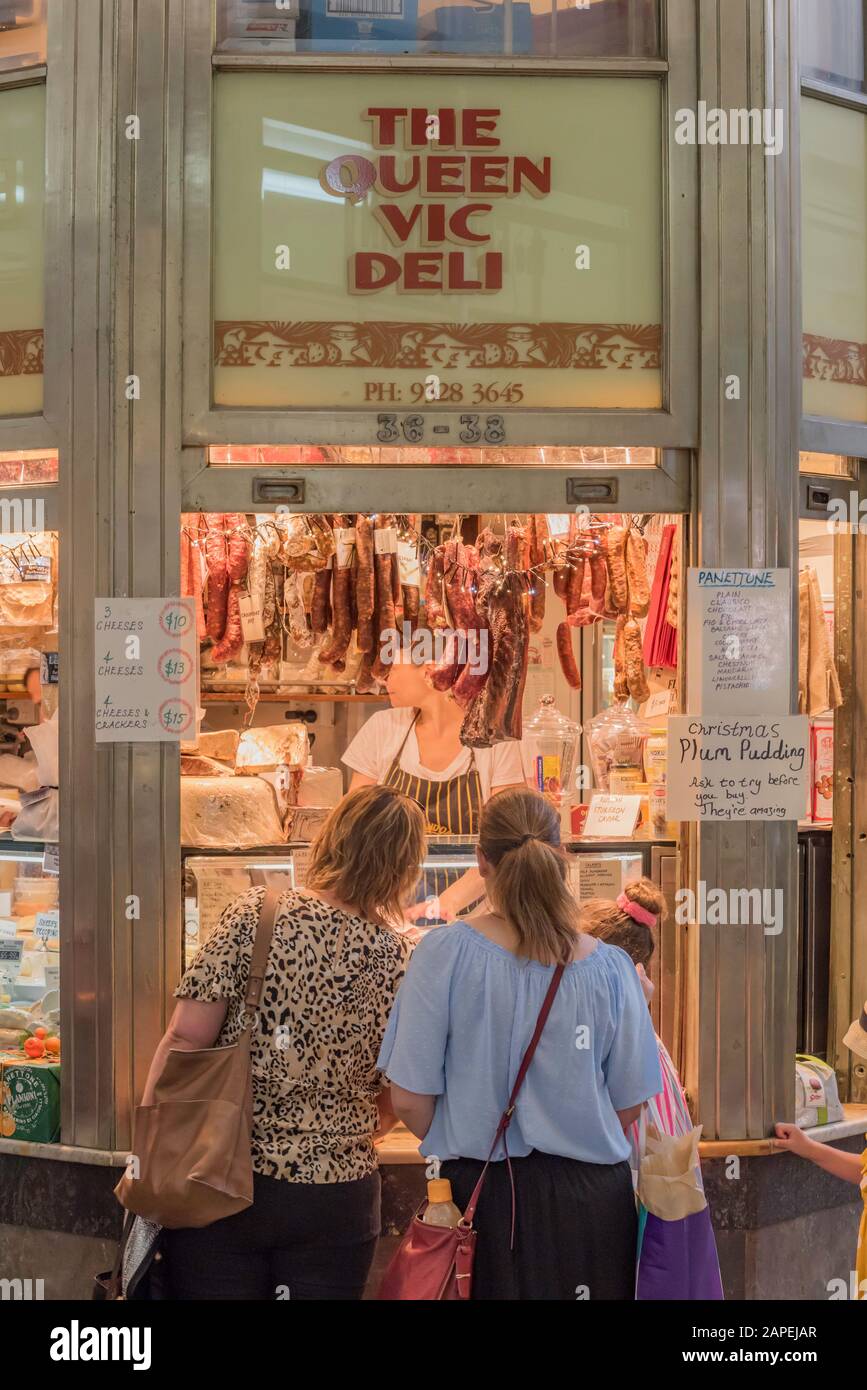 People buying and selling cold meats and cheeses at the indoor section