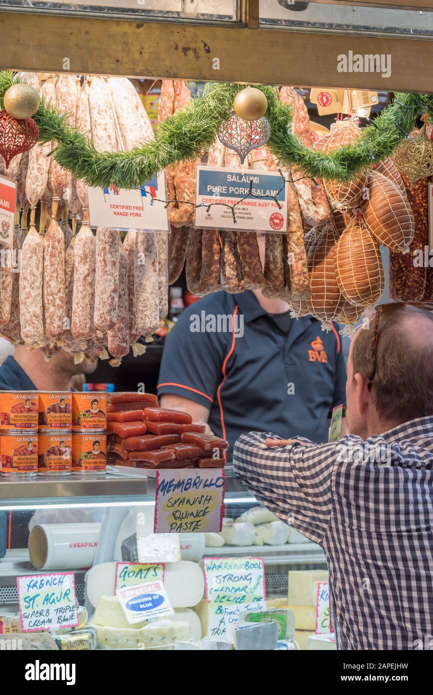 People buying and selling cold meats and cheeses at the indoor section
