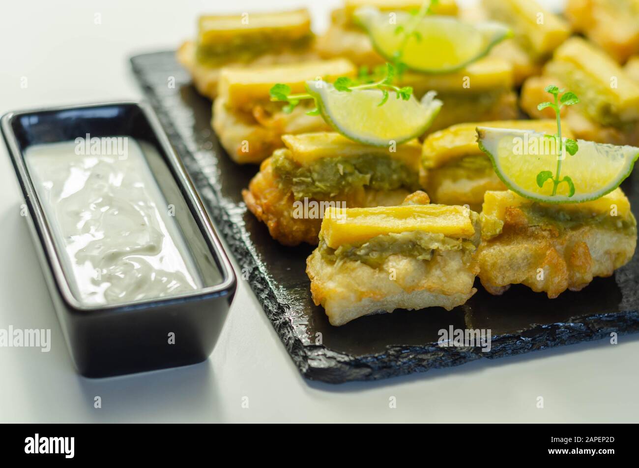 Skinless and boneless battered Alaska Pollock fillet pieces, topped with mushy peas and fried