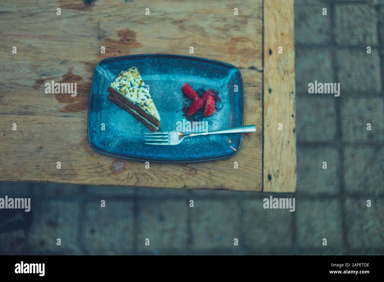 A cake with strawberries on a plate outdoors Stock Photo