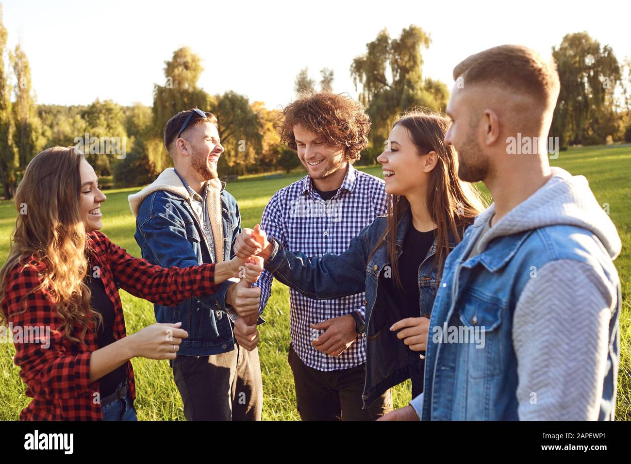 Group of friends connected thumb up in the park. Stock Photo