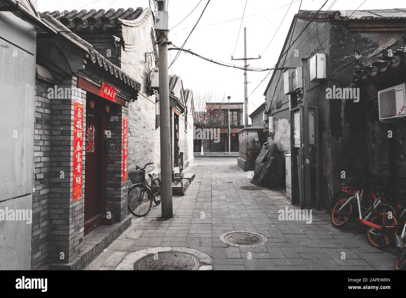 Decorated street / hutong / small alley in Beijing during the Chinese New Year, also referred to as the spring festival. With bicycles, old buildings Stock Photo