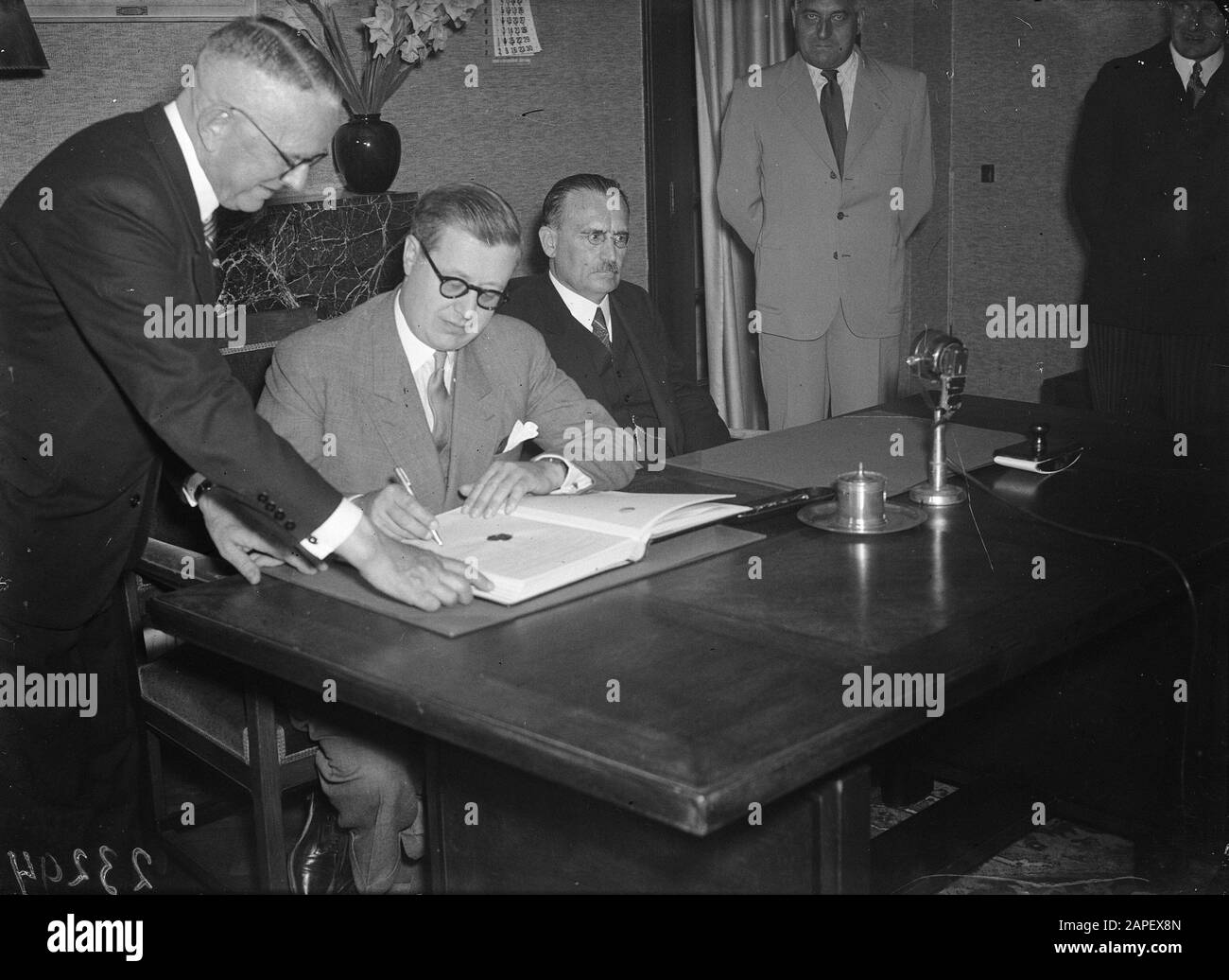 Belgian Minister L.E. Troclet signs the Mutual Insurance Agreement between Belgium and the Netherlands. To the right of him Minister of Social Affairs W. Drees Date: 29 August 1947 Keywords: international agreements, ministers Personal name: Drees, Willem (sr.), Troclet, L.E. Stock Photo
