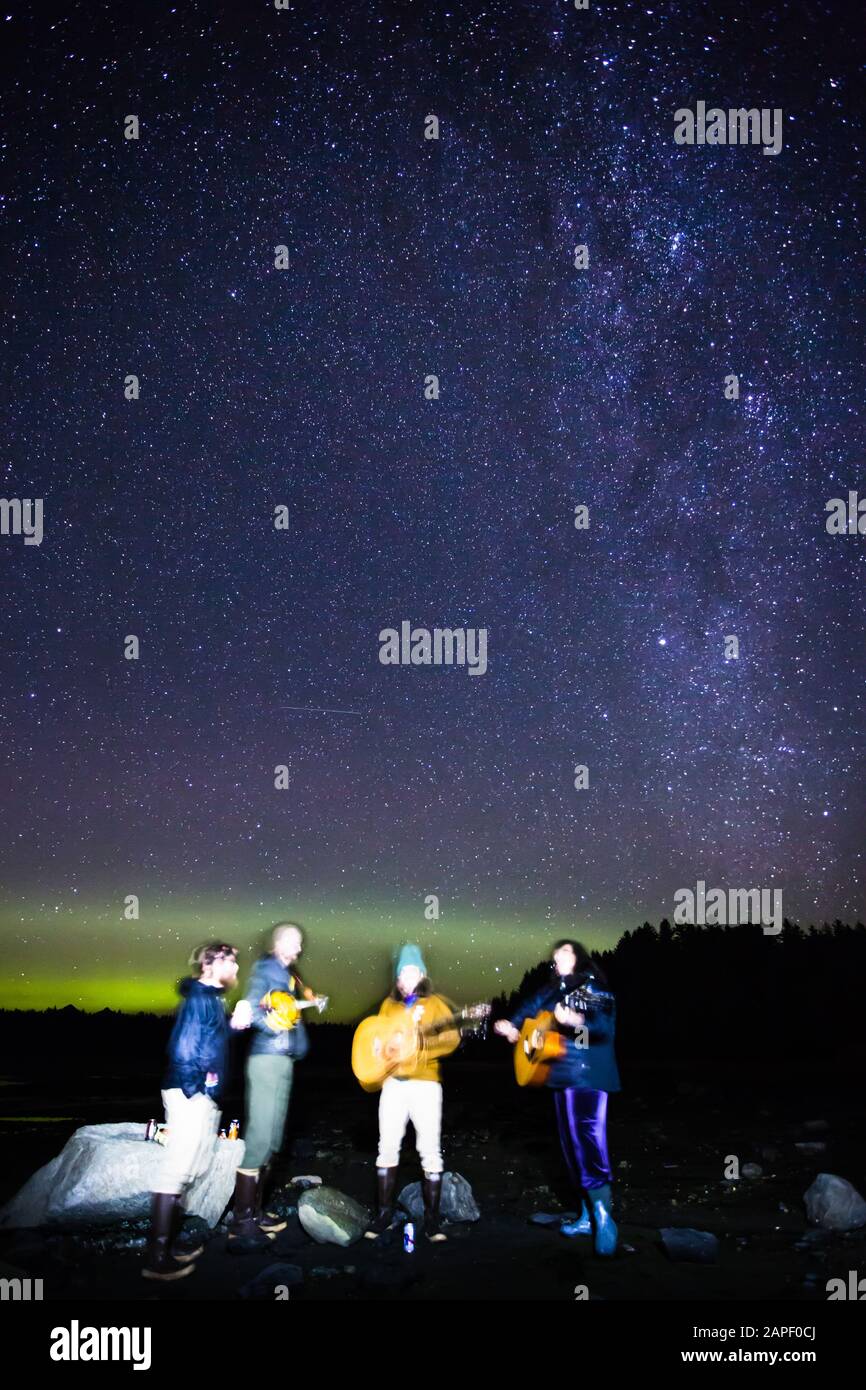 A band of four musicians plays under the Northern Lights and the Milky