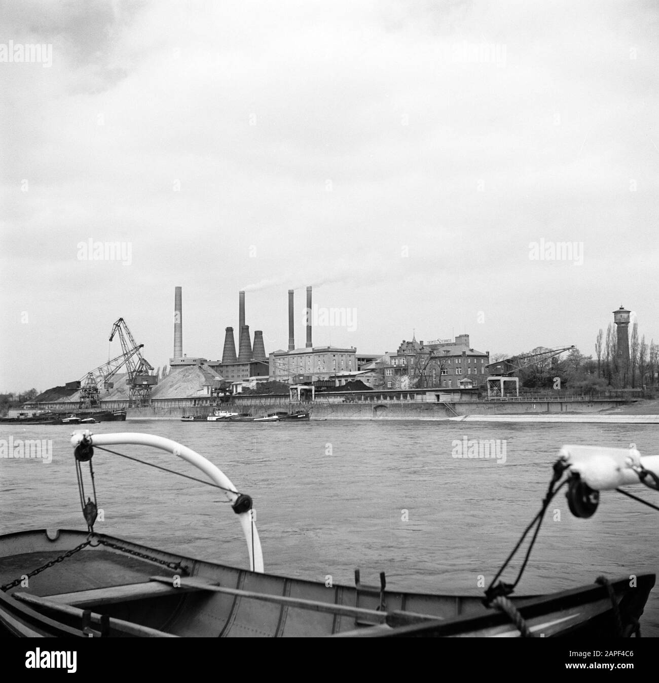 Rhine navigation, report from tug Damco 9: West Germany Description: Bonner  Zement factory at Oberkassel Date: April 1, 1955 Location: Bonn, Germany,  Oberkassel, West Germany Keywords: factors, cranes, lifeboats, rivers,  chimneys, towers