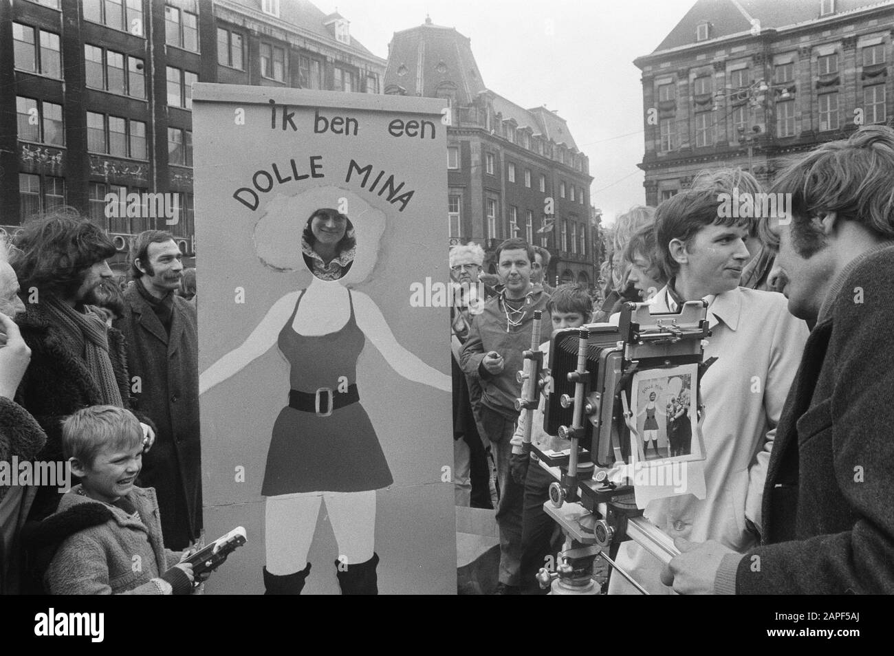 Dolle Minas op de Dam Description: Board allowing people to be photographed as Dolle Mina Date: 30 april 1970 Location: Amsterdam, Noord-Holland Keywords: Dolle Mina, signs, photographers, fairground attractions, women emancipation Institution name: Dolle Mina Stock Photo