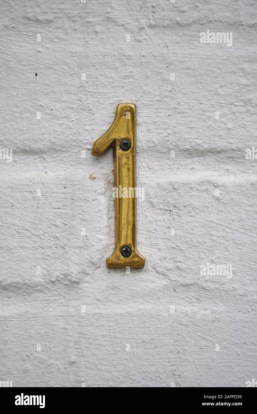 A house number plaque, showing the number one (1) Stock Photo