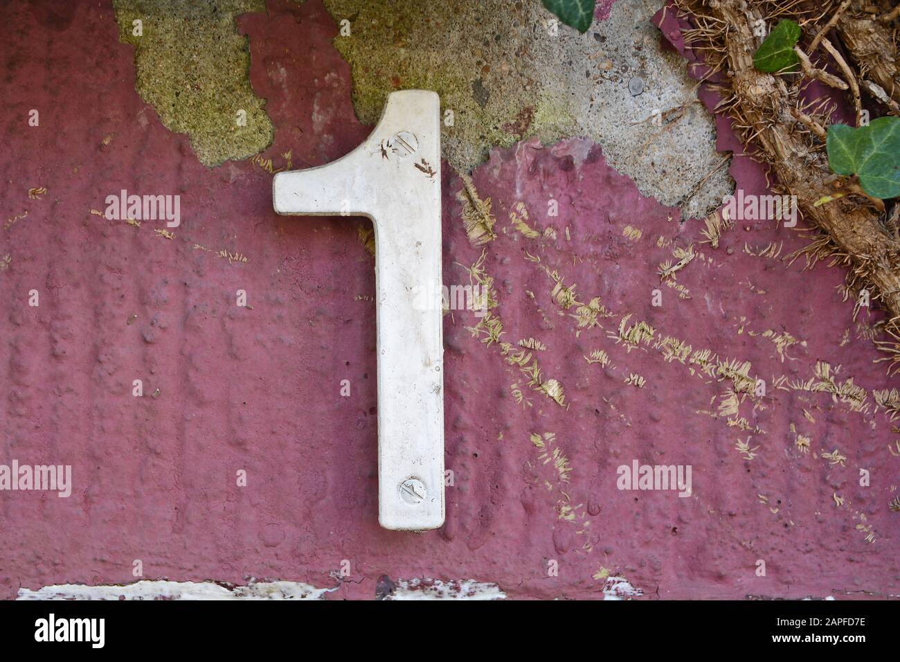 A house number plaque, showing the number one (1) Stock Photo