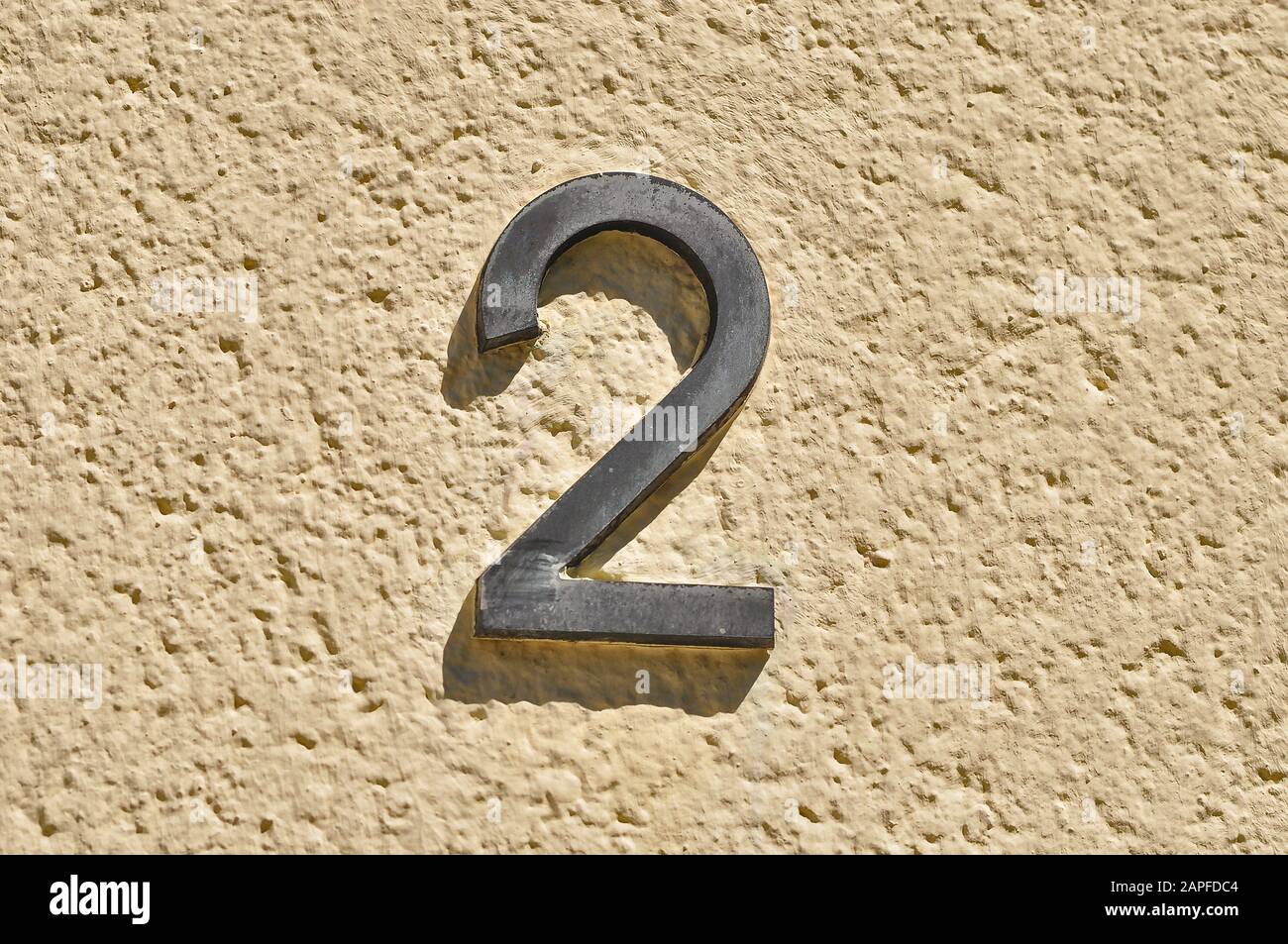 A house number plaque, showing the number two (2) Stock Photo