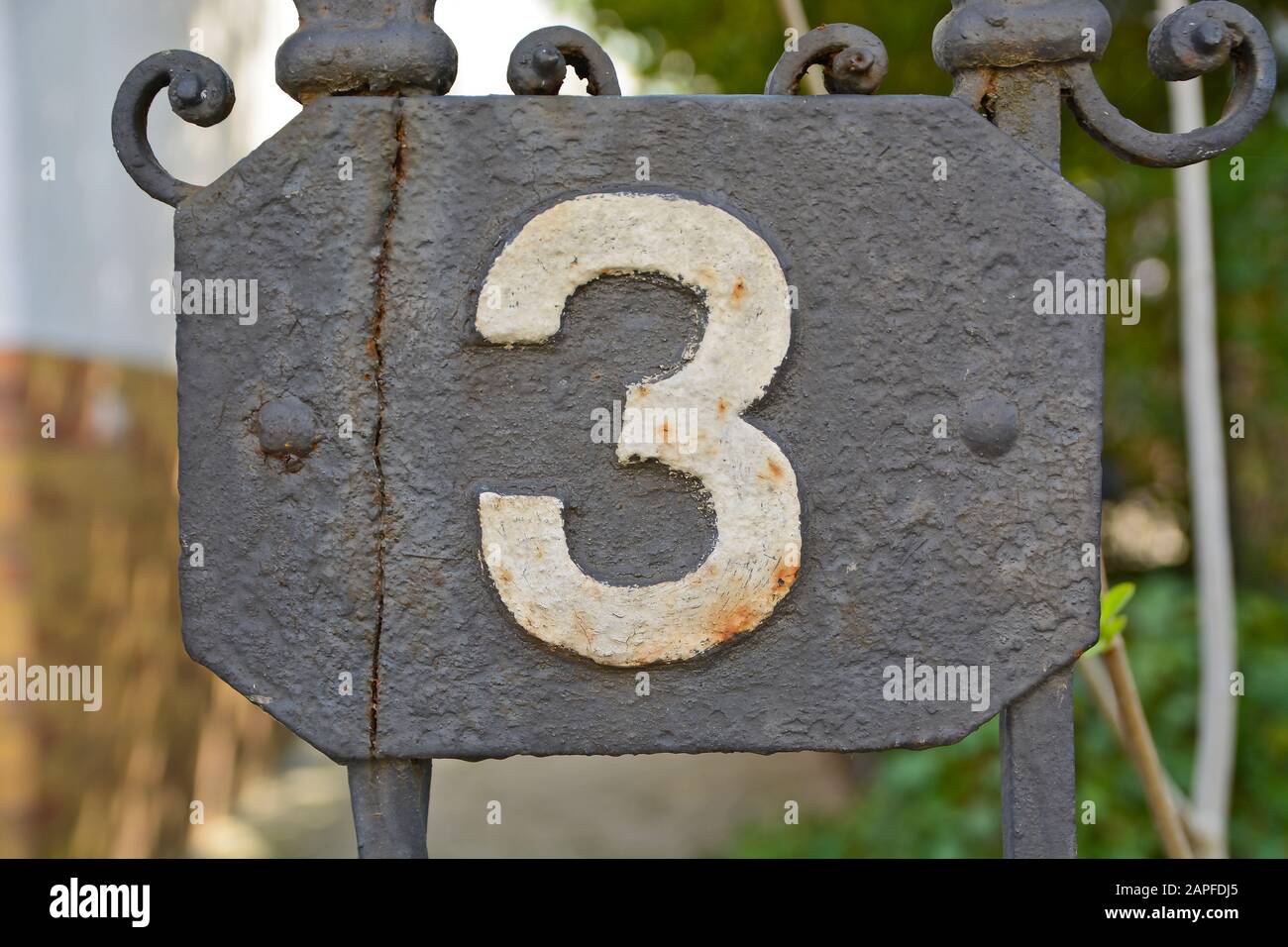 A house number plaque, showing the number three (3) Stock Photo
