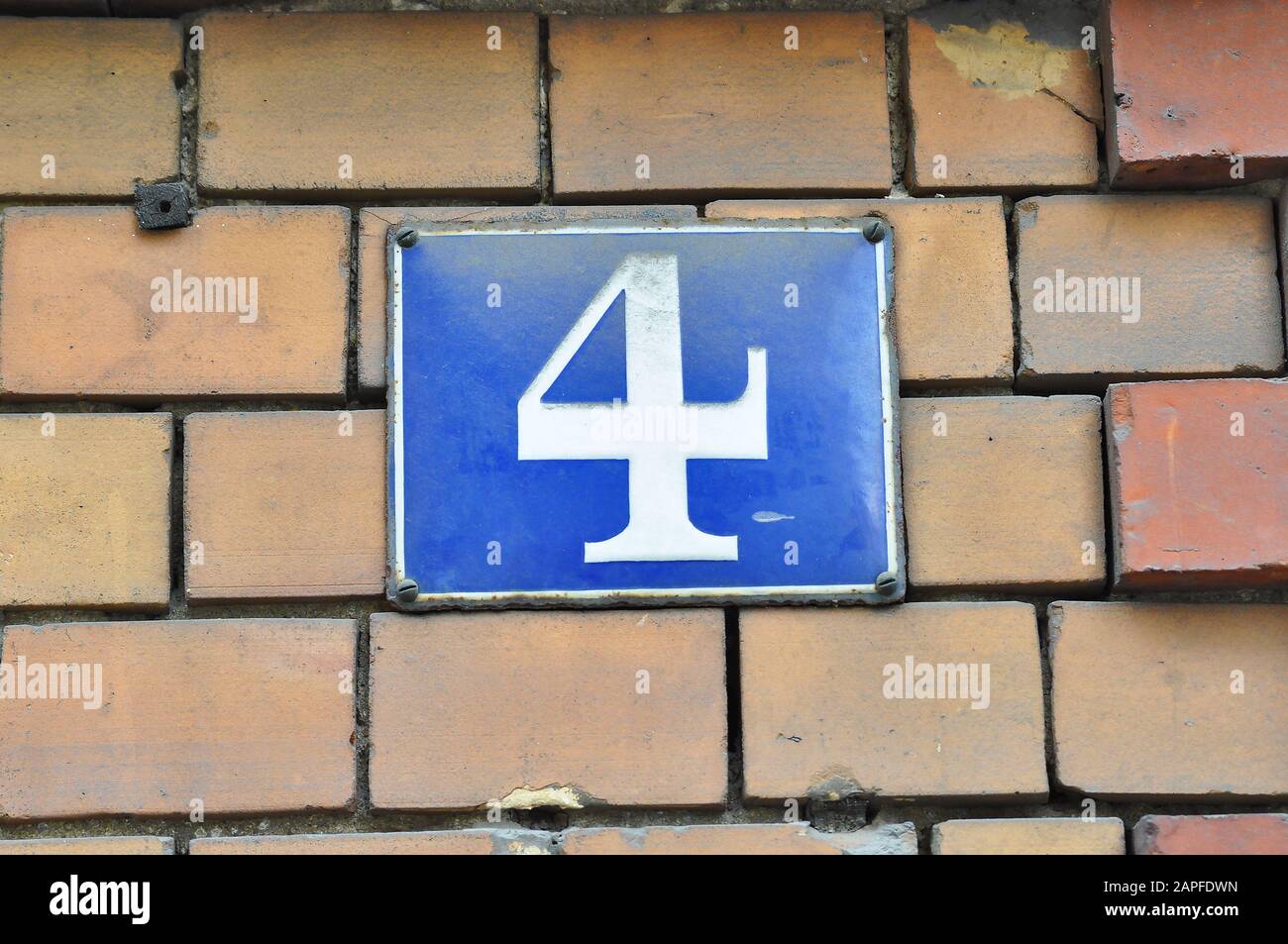 A house number plaque, showing the number four (4) Stock Photo