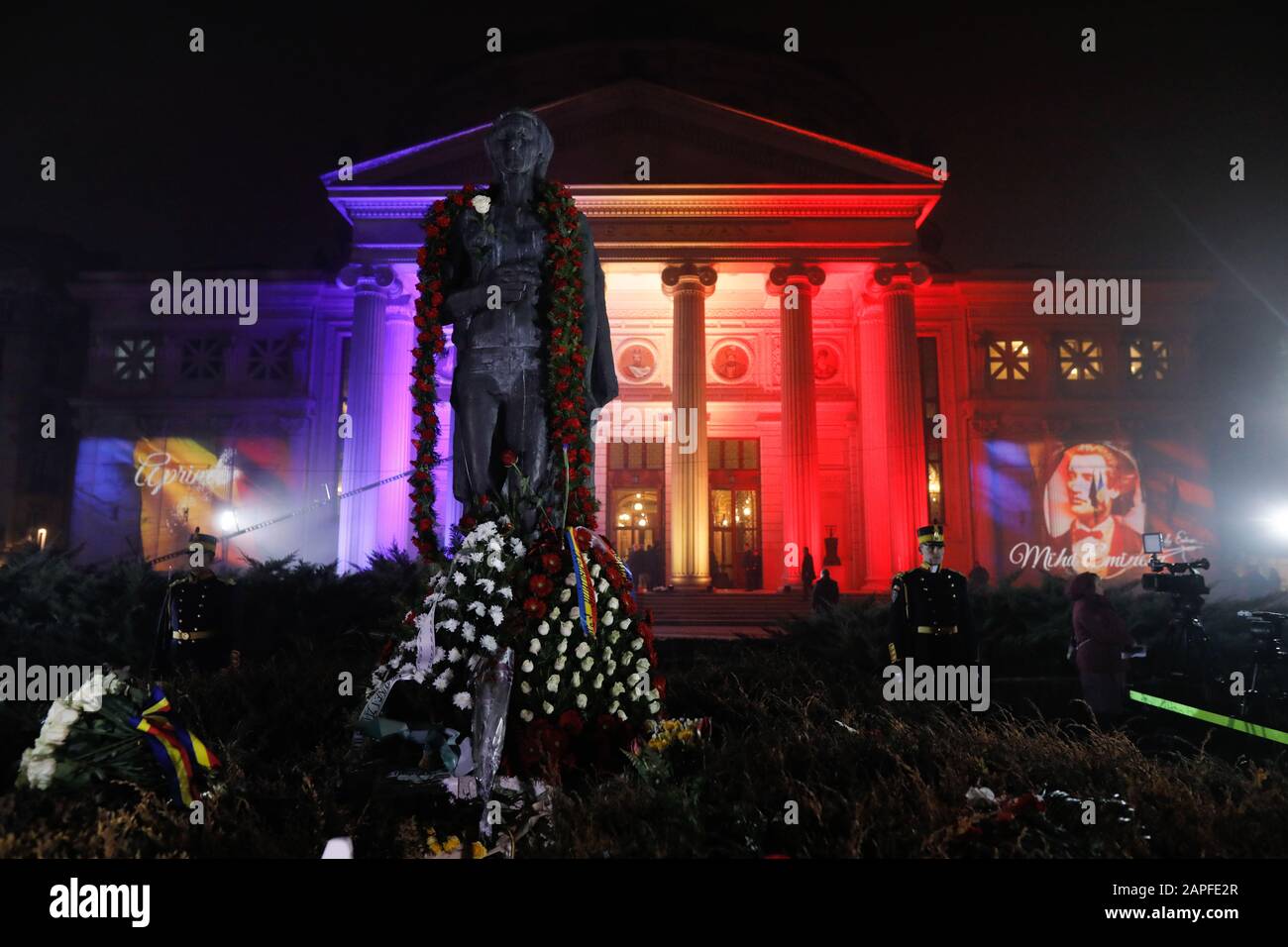 Bucharest, Romania - January 15, 2020: Romanian flag projected on the Athenaeum and Mihai Eminescu image (his statue in the foreground) during the poe Stock Photo