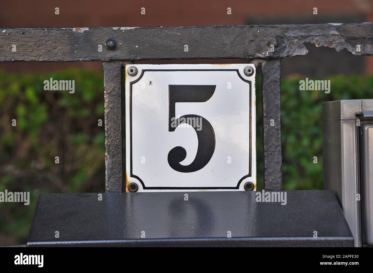 A house number plaque, showing the number five (5) Stock Photo