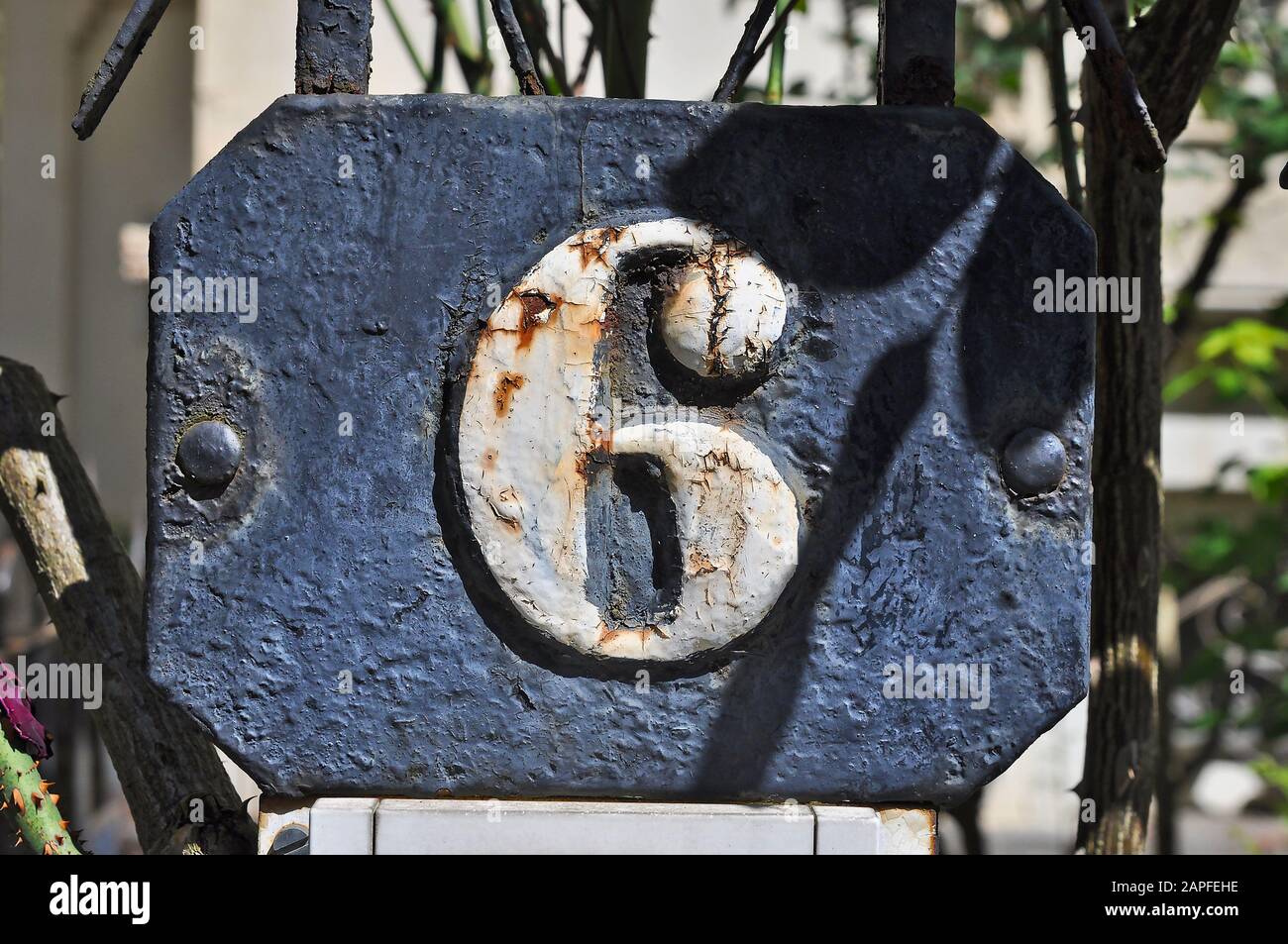 A house number plaque, showing the number six (6) Stock Photo