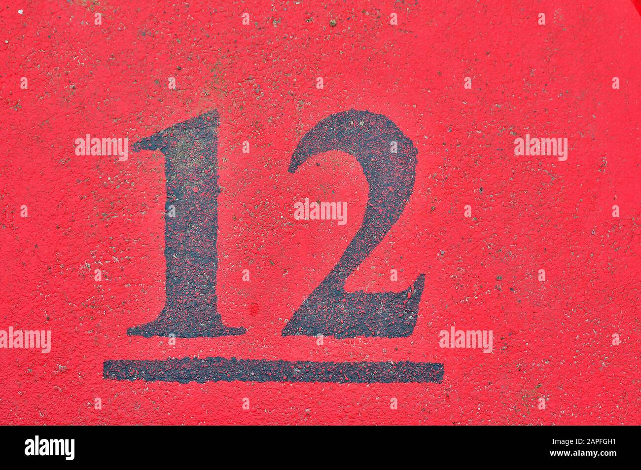 A house number plaque, showing the number twelve (12) Stock Photo