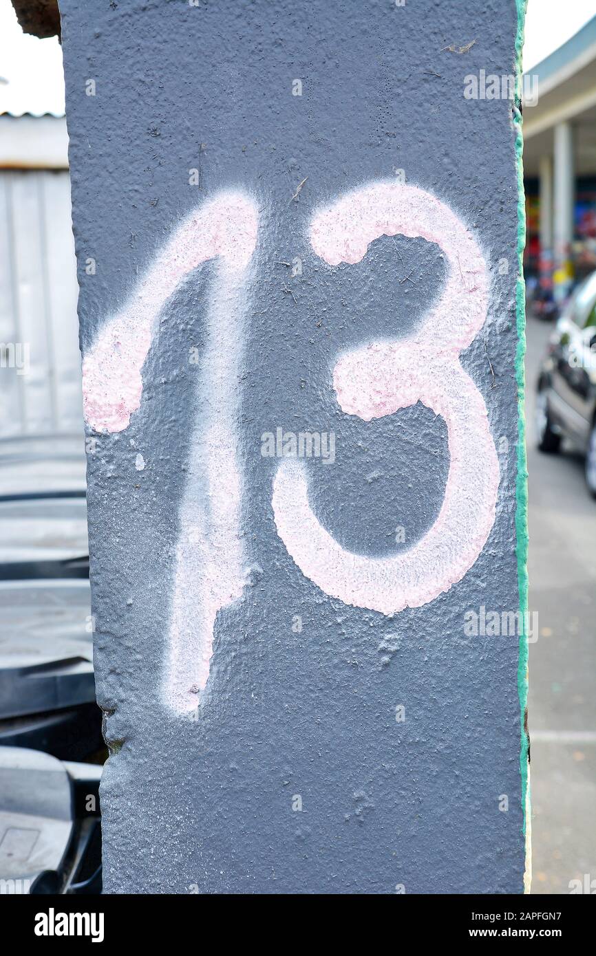 A house number plaque, showing the number thirteen (13) Stock Photo