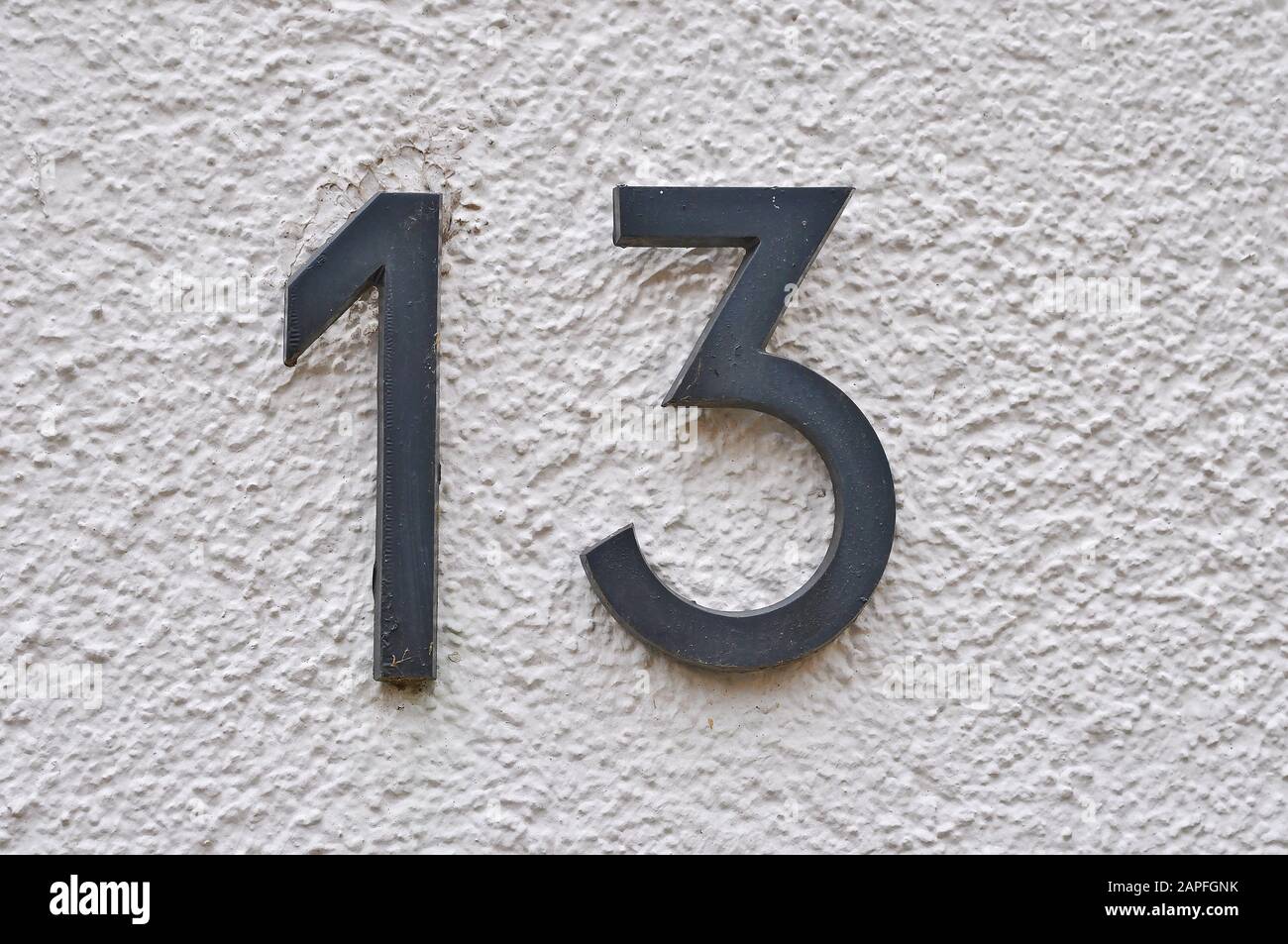 A house number plaque, showing the number thirteen (13) Stock Photo