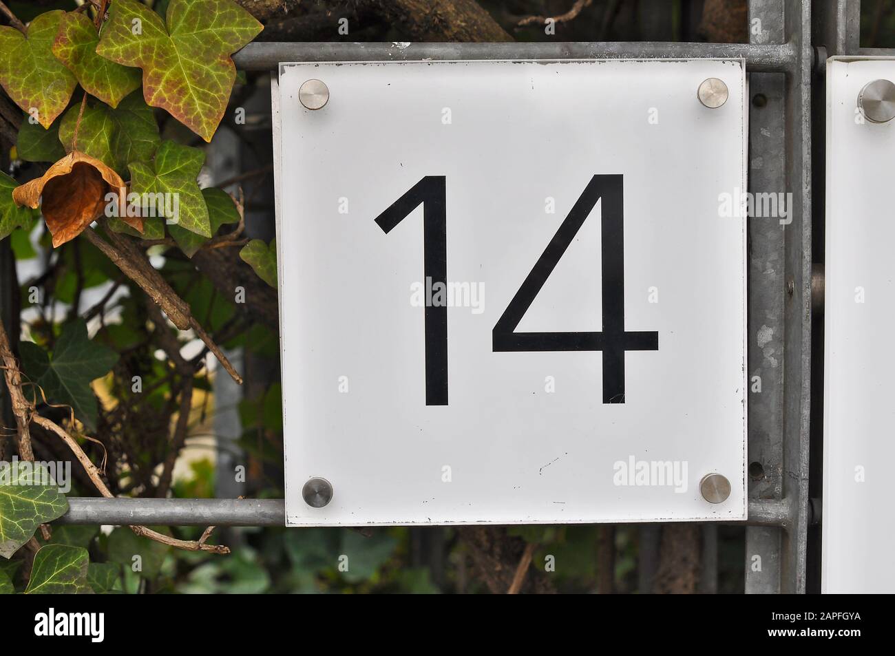 A house number plaque, showing the number fourteen (14) Stock Photo