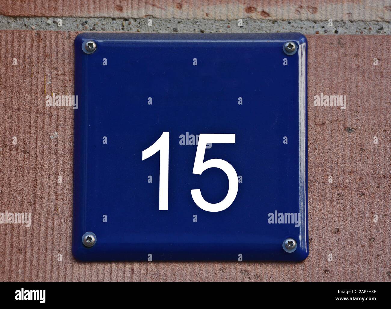 A blue house number plaque, showing the white coloured number fifteen (15) Stock Photo