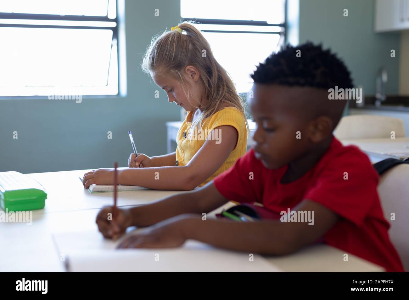 Schoolchildren writing during a lesson in an elementary school classroom Stock Photo