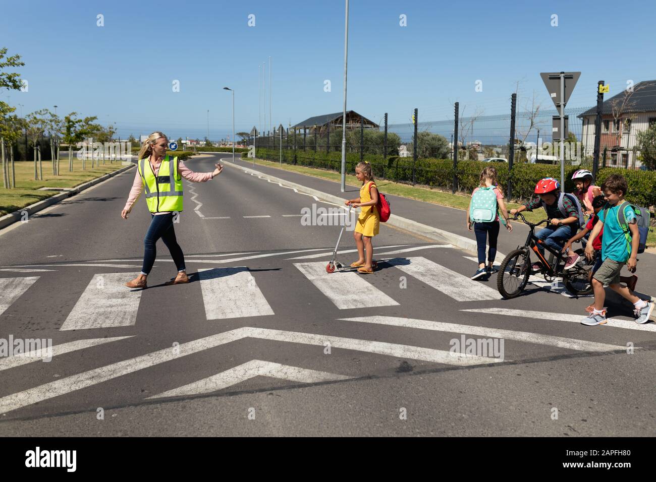 Woman wearing a high visibility vest on a pedestrian crossing Stock Photo