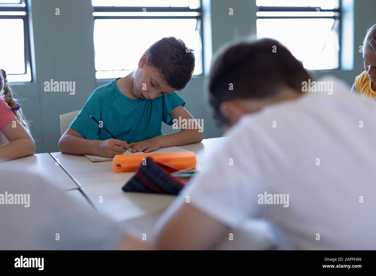 Schoolboy writing during a lesson in an elementary school classroom Stock Photo