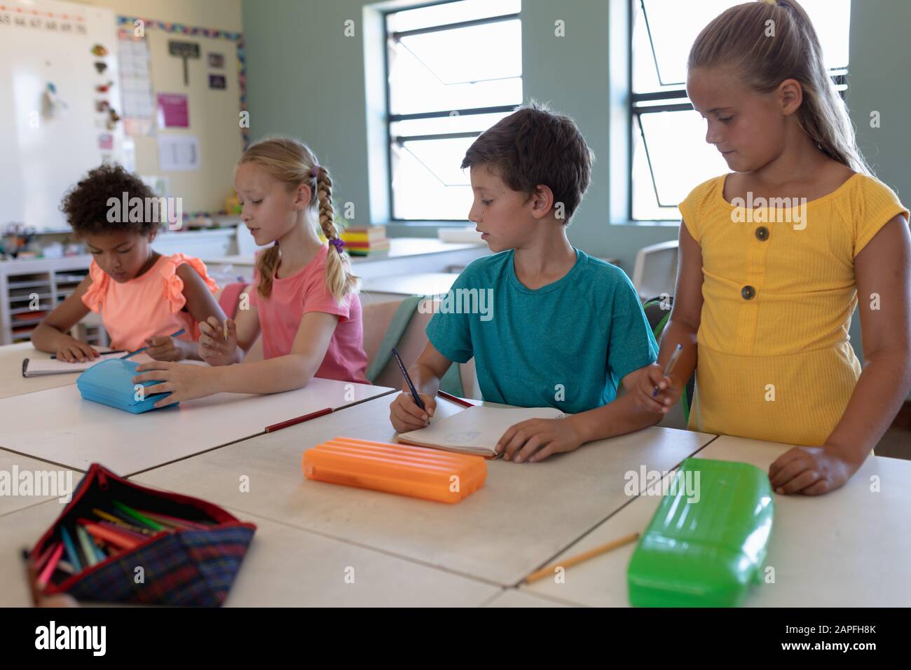 Group of schoolchildren working in an elementary school classroom Stock Photo
