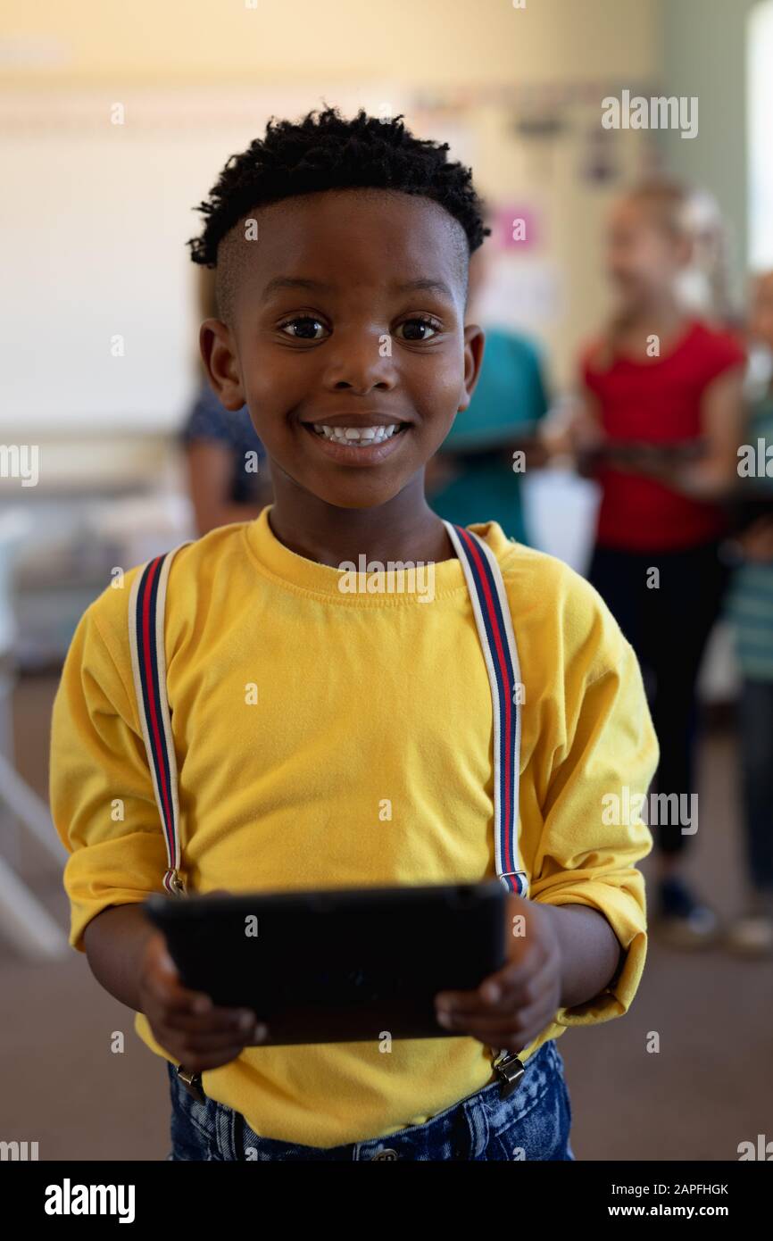 Schoolboy using a tablet computer in an elementary school classroom Stock Photo