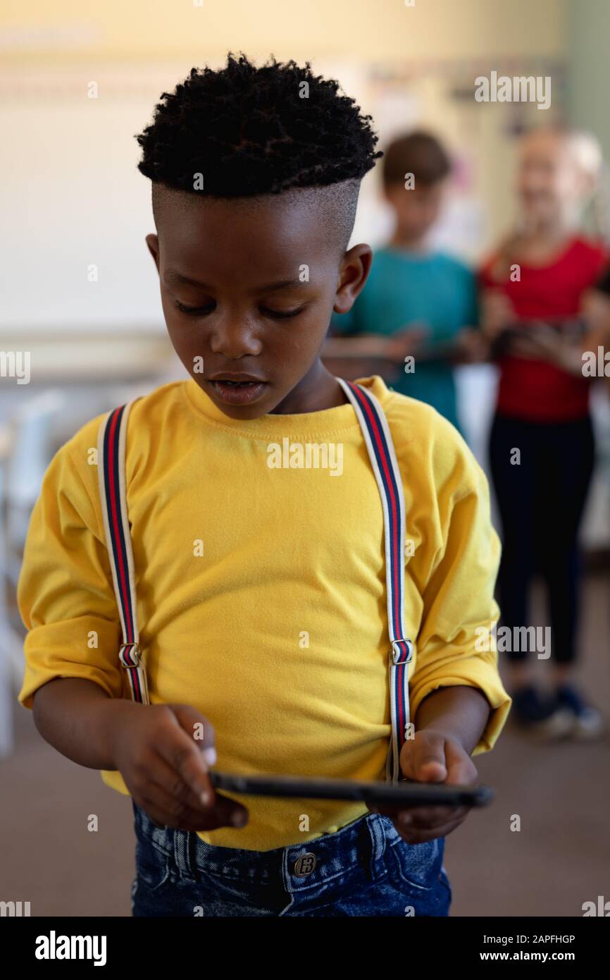 Schoolboy using a tablet computer in an elementary school classroom Stock Photo