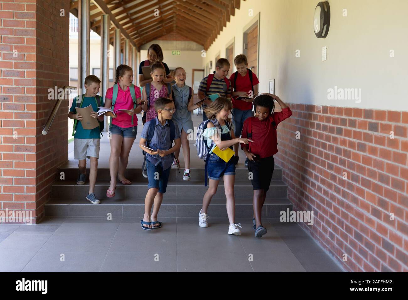 Group of school pupils walking in an outdoor corridor at elementary school Stock Photo