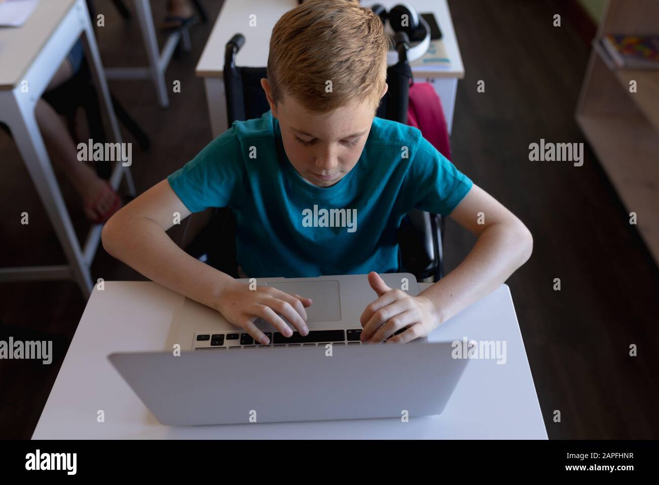 Schoolboy sitting at a desk using a laptop computer Stock Photo - Alamy