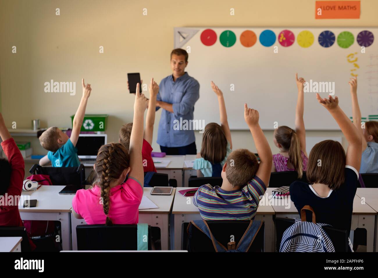 Male school teacher standing in an elementary school classroom Stock Photo