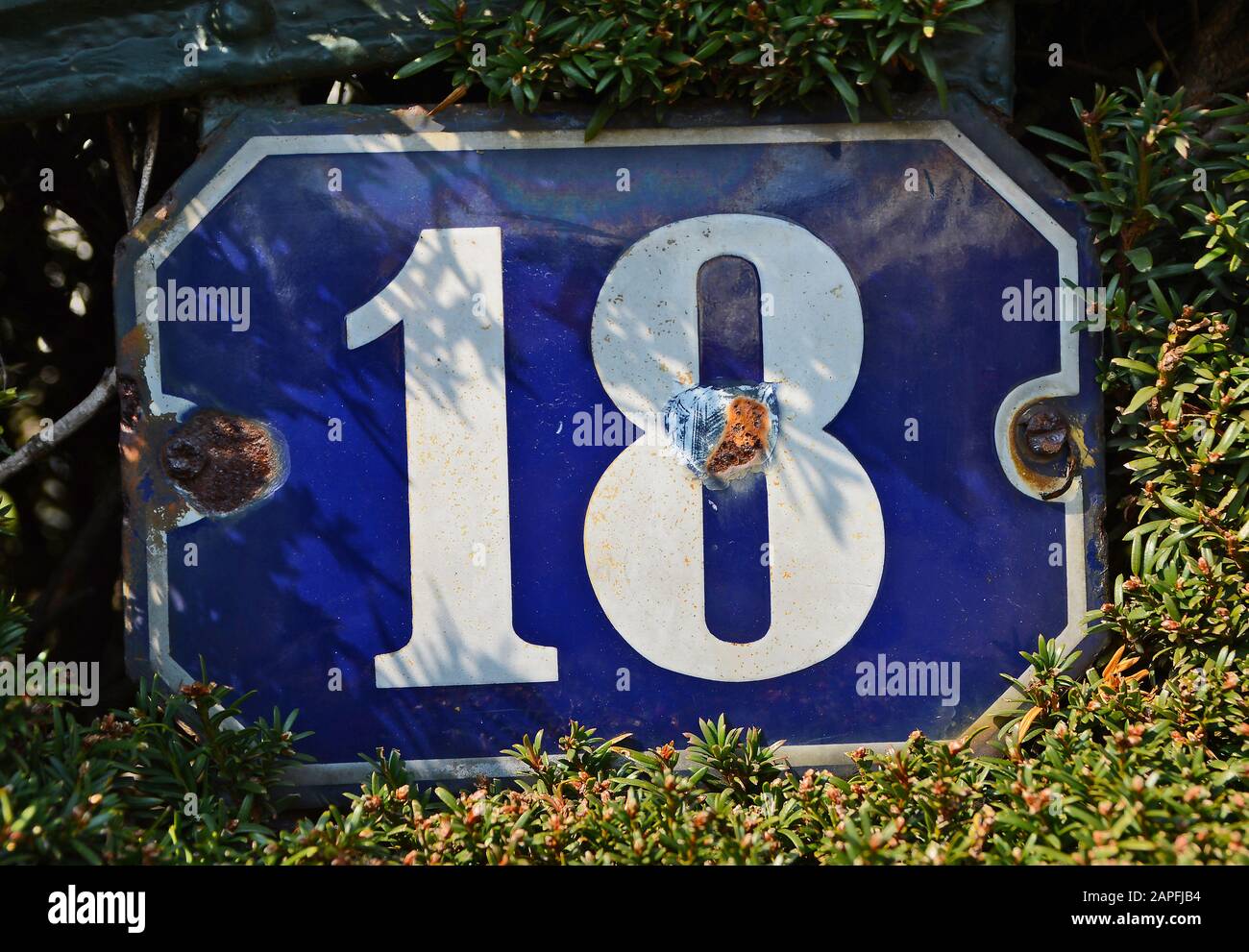 A house number plaque, showing the number eighteen (18) Stock Photo