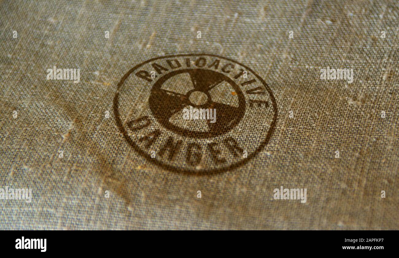 Radioactive danger symbol stamp printed on linen sack. Atomic energy warning, radiation alert and nuclear power hazard concept. Stock Photo