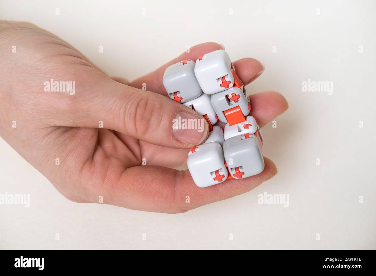 Colorful fingers antistress fidget cube toy in hand on white background.  development of fine motor skills of fingers of children Stock Photo - Alamy