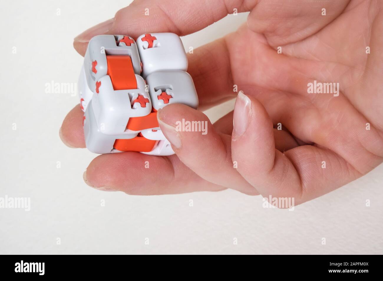 Colorful fingers antistress fidget cube toy in hand on white background.  development of fine motor skills of fingers of children Stock Photo - Alamy