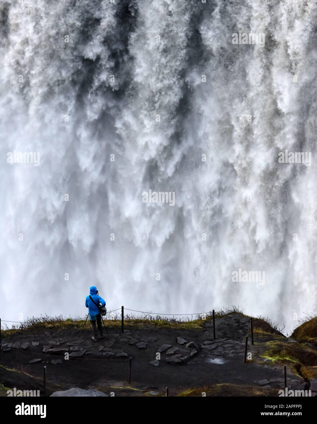 Lonely tourist near gorgeus Dettifoss waterfall - most powerful waterfall in Europe. Jokulsargljufur National Park, Iceland. Landscape photography Stock Photo