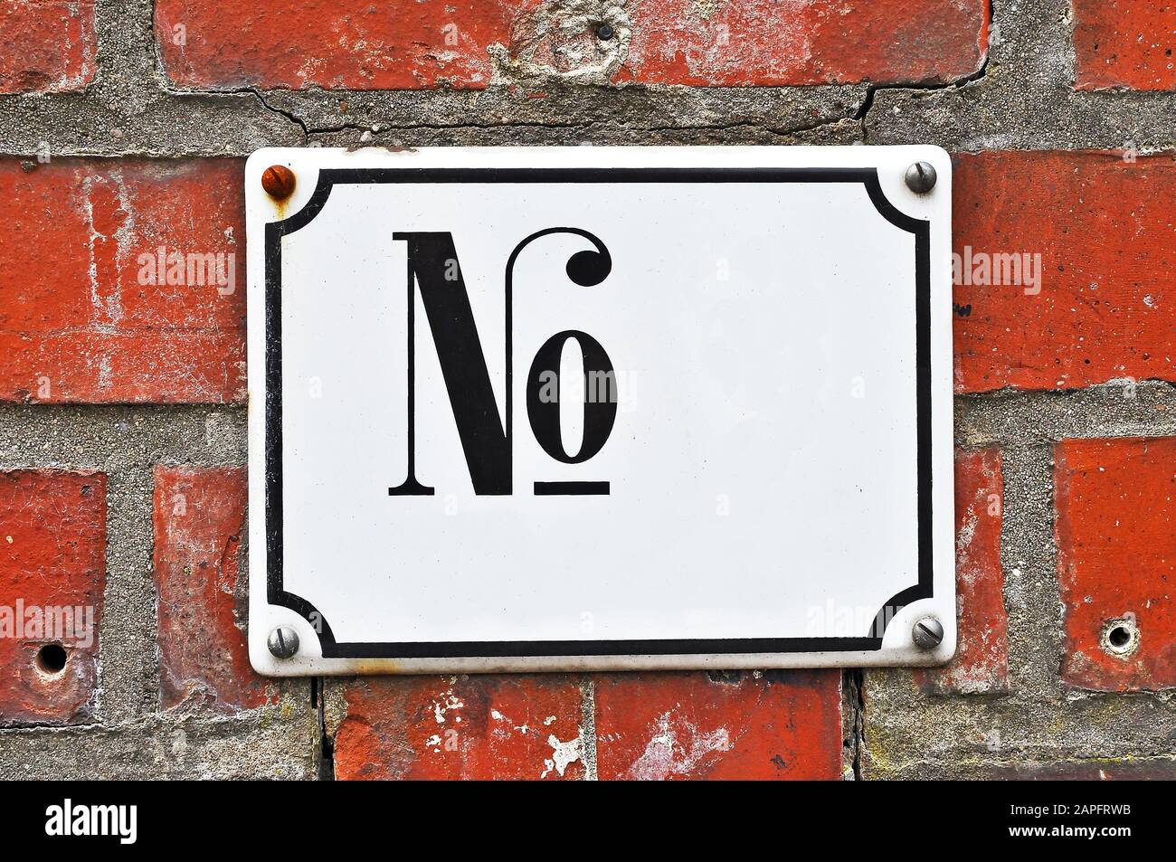 A white colored house number plaque, with the abbreviation 'No.', fixed on a brick wall. Mock up/ template for designers Stock Photo