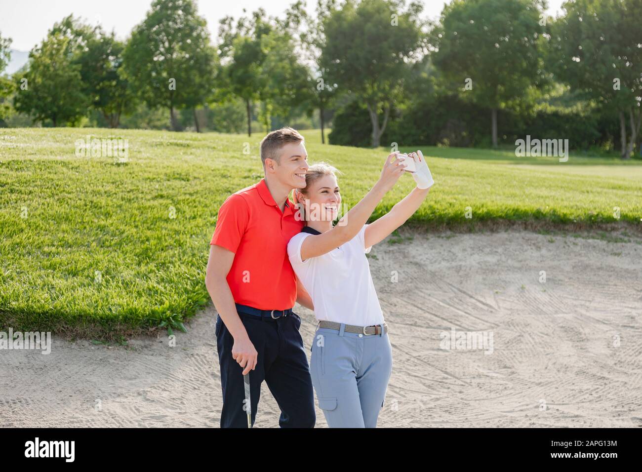 Couple taking selfie on golf course Stock Photo