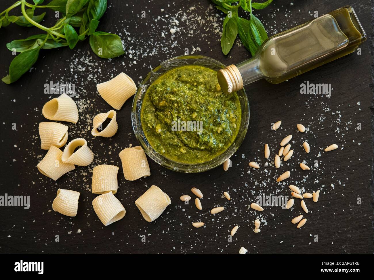 Pesto sauce, basil, pine nuts, rigatoni, cheese flakes Stock Photo
