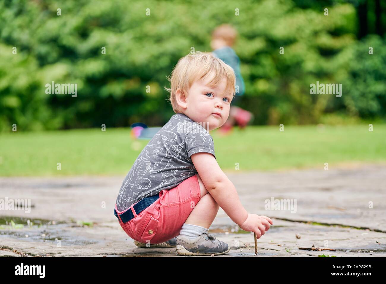 Toddlers exploring park Stock Photo
