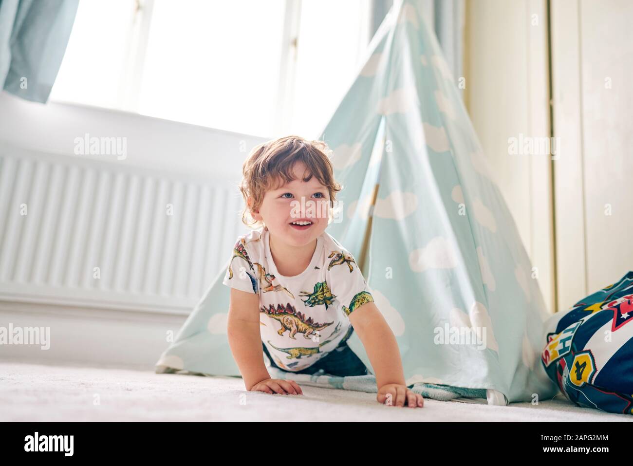 Toddler playing in a teepee in his bedroom at home Stock Photo