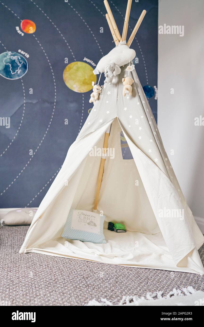 Child's teepee, mural of solar system on wall Stock Photo