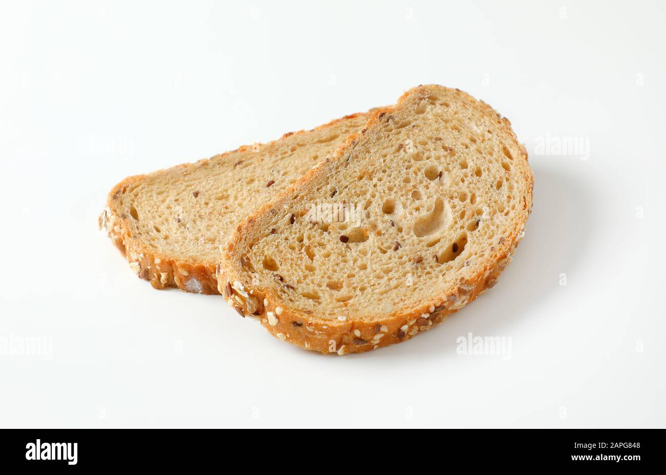 Two slices of whole grain bread, crust topped with rolled oats and seeds (flax, sesame, sunflower) Stock Photo