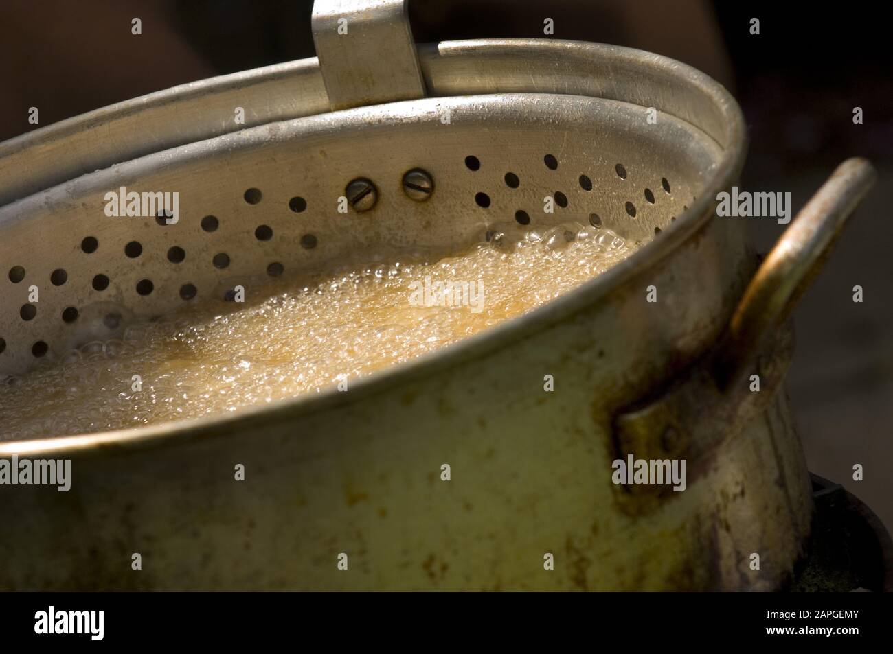 Closeup of a boiling dish in a rusty old pot under the lights with a blurry background Stock Photo