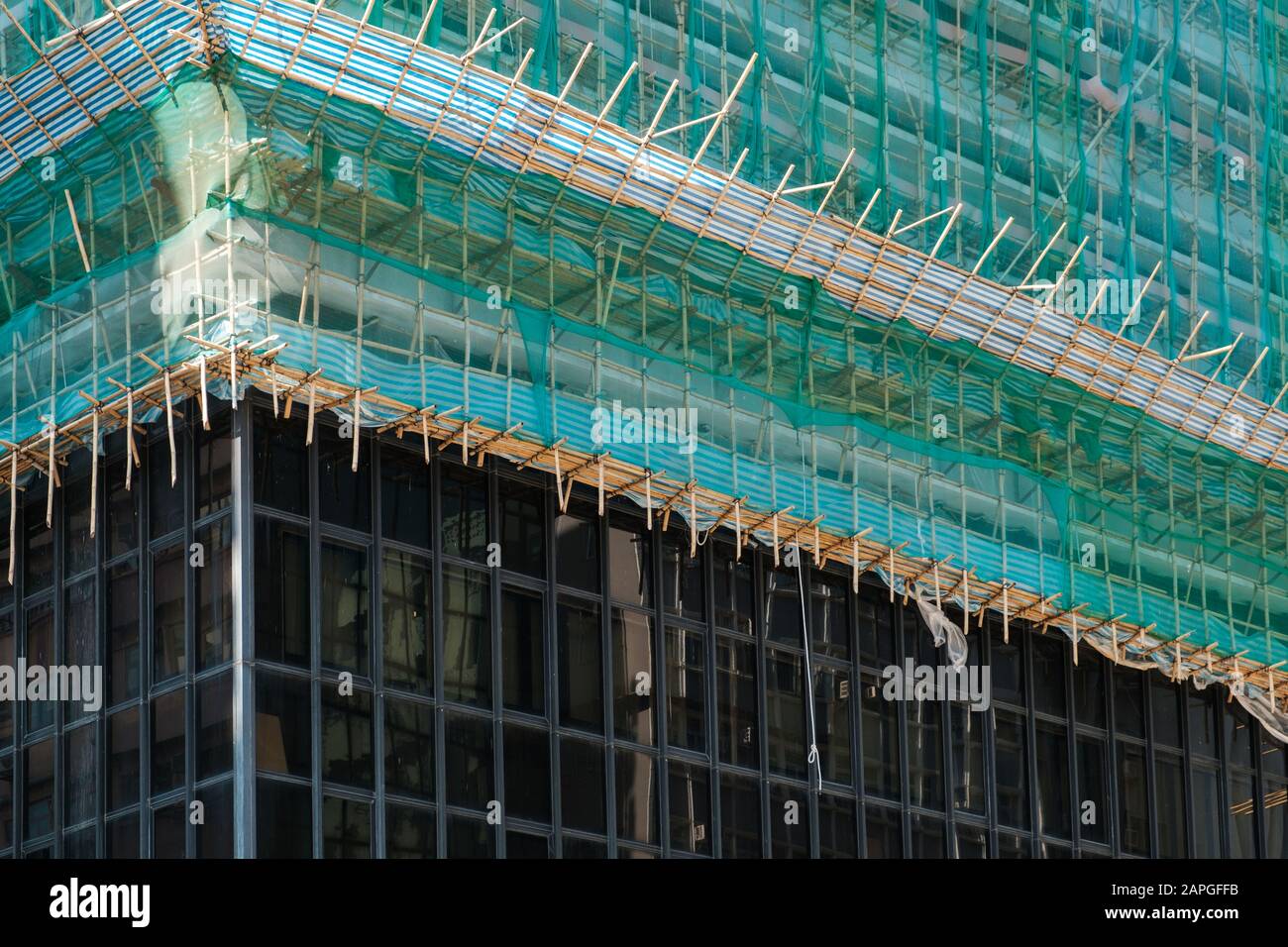 Bamboo pole scaffolding on building construction site - Stock Photo