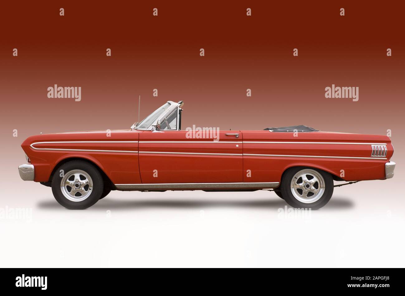 Red convertible car under the lights against a light red background Stock Photo